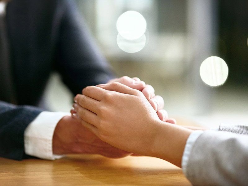 Handshake across a desk during a consultation